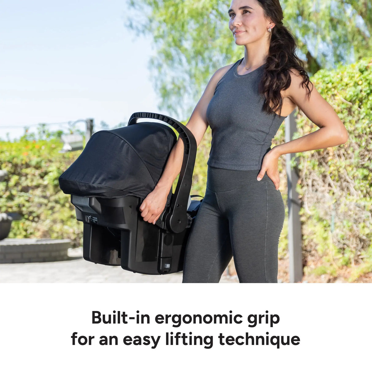 A mom using the built in ergonomic grip for an easy lifting from the Baby Trend EZ-Lift PLUS Infant Car Seat