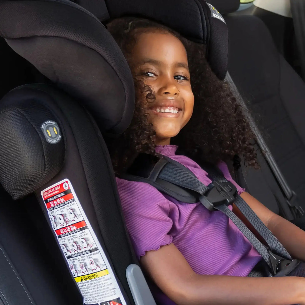 A child sitting in the Baby Trend Hybrid Combination Booster Car Seat