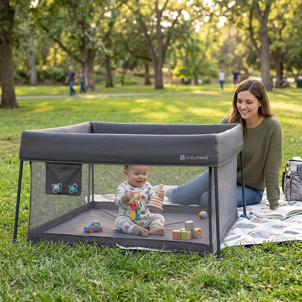A mom and her child outside at the park using the Baby Trend Play Zone Play Space