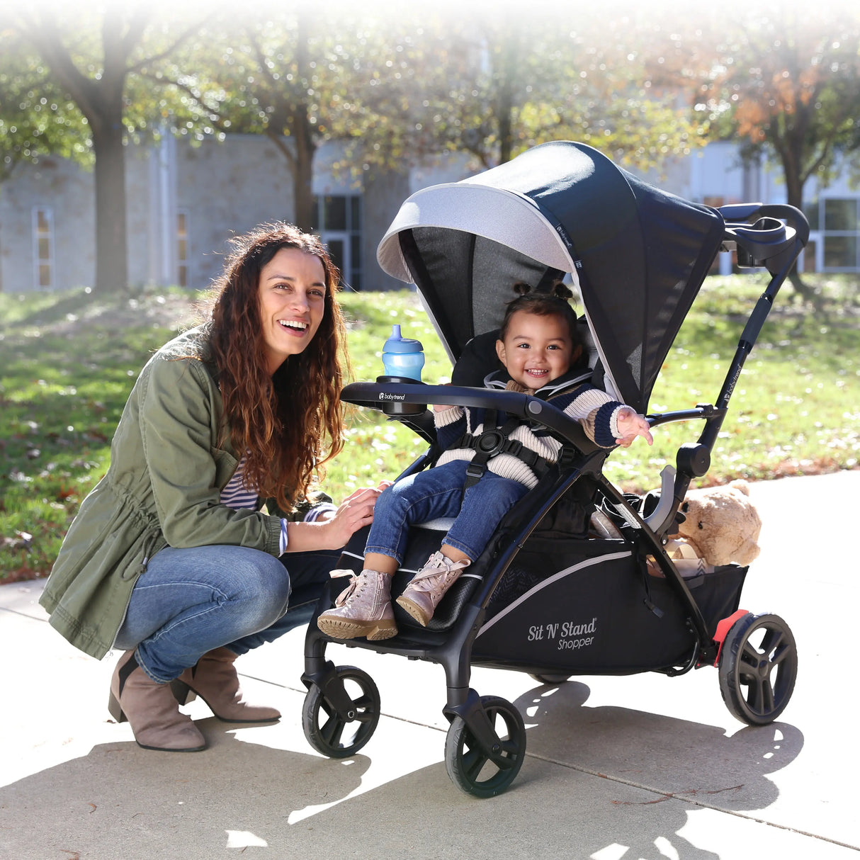 A mother with her child in the Baby Trend Sit N Stand 5-in-1 Shopper Stroller at a park