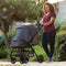 Mom is outdoor with her child in the Baby Trend Passport Carriage Stroller