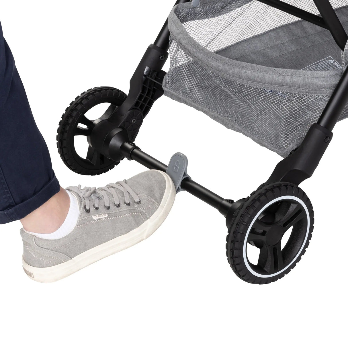 A person is using their food is press the brake on the Baby Trend Zenda Compact All-Terrain Stroller