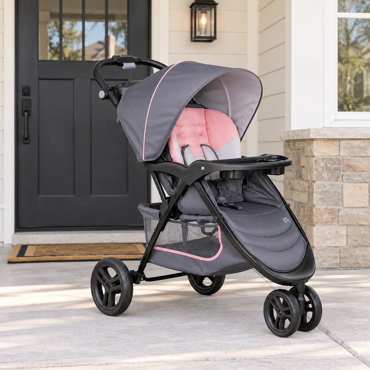 The Baby Trend EZ Ride Stroller is parked in front of a door home