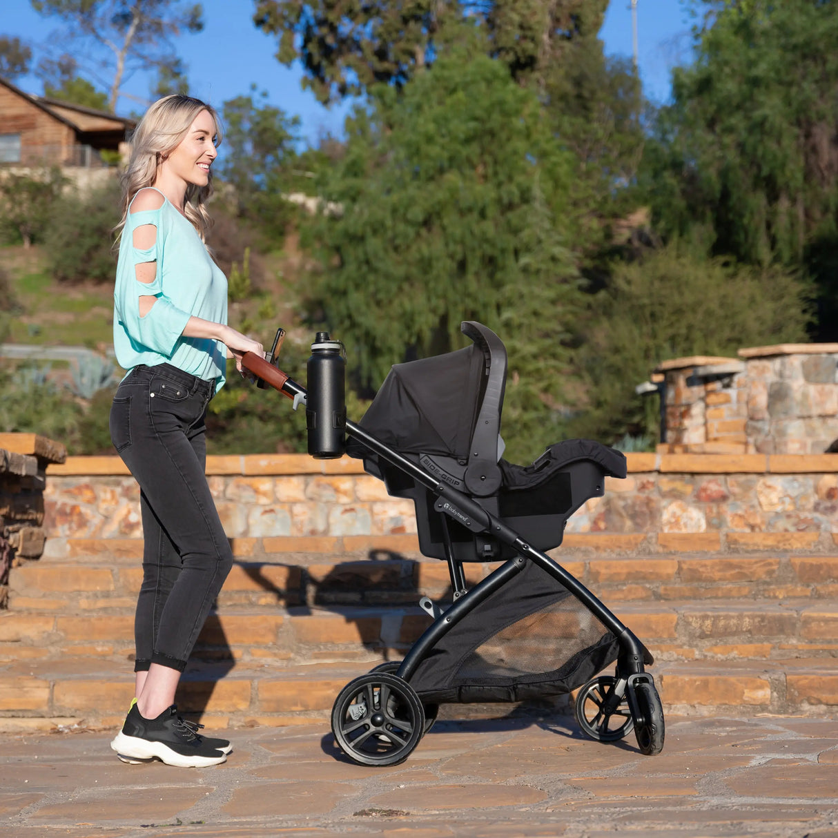 A mom is pushing her baby in the Baby Trend Passport Switch 6-in-1 Modular Stroller