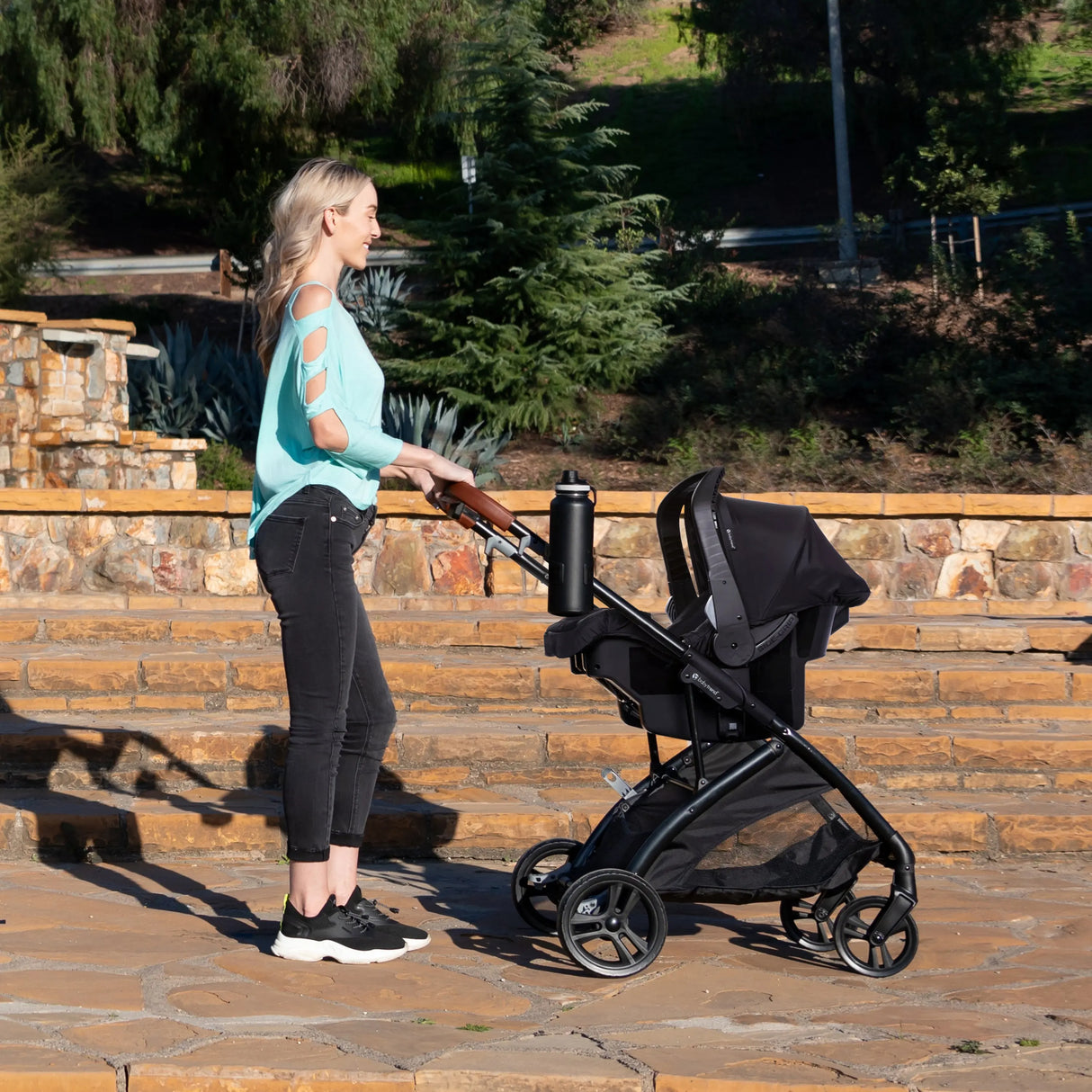 A mom is pushing her baby in the Baby Trend Passport Switch 6-in-1 Modular Stroller