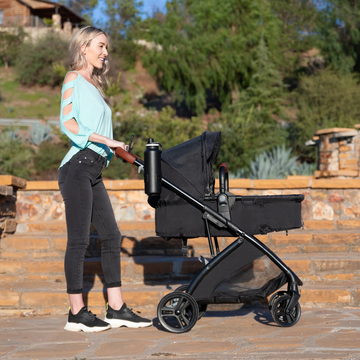 A mom is pushing her baby in the Baby Trend Passport Switch 6-in-1 Modular Stroller