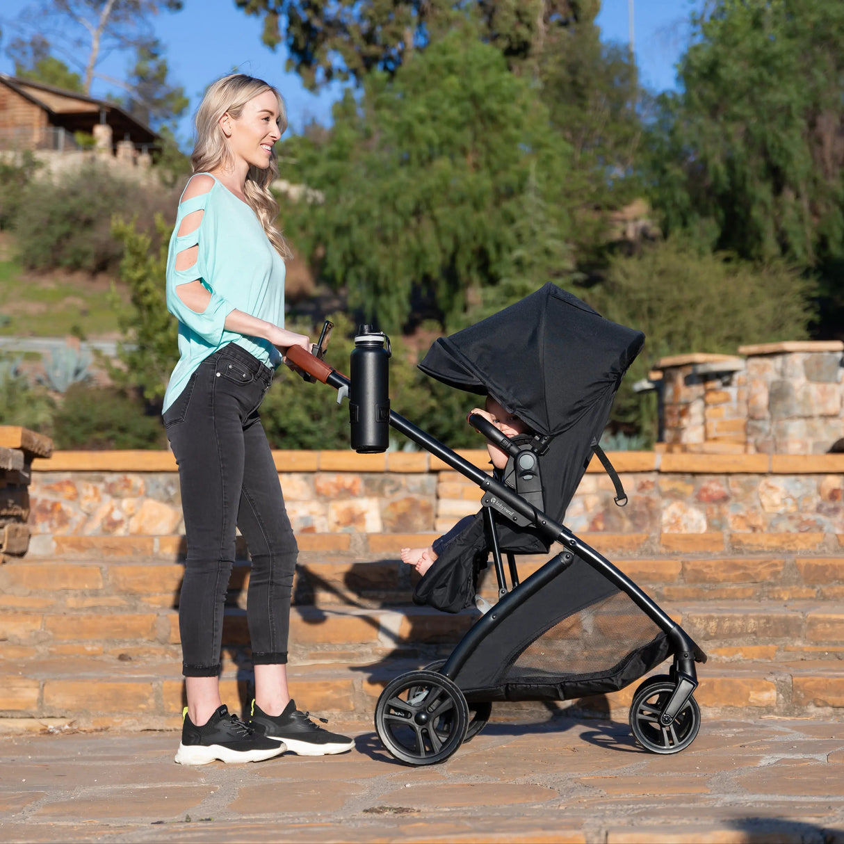 A mom is pushing her baby in the Baby Trend Passport Switch 6-in-1 Modular Stroller