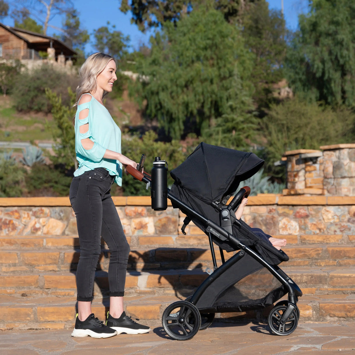 A mom is pushing her baby in the Baby Trend Passport Switch 6-in-1 Modular Stroller