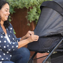 Load image into gallery viewer, A mom is using the full netting cover on the seat of the Baby Trend Passport Carriage DLX Stroller Travel System