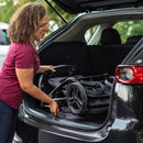 Load image into gallery viewer, Mom is putting her Baby Trend stroller into the back of her car