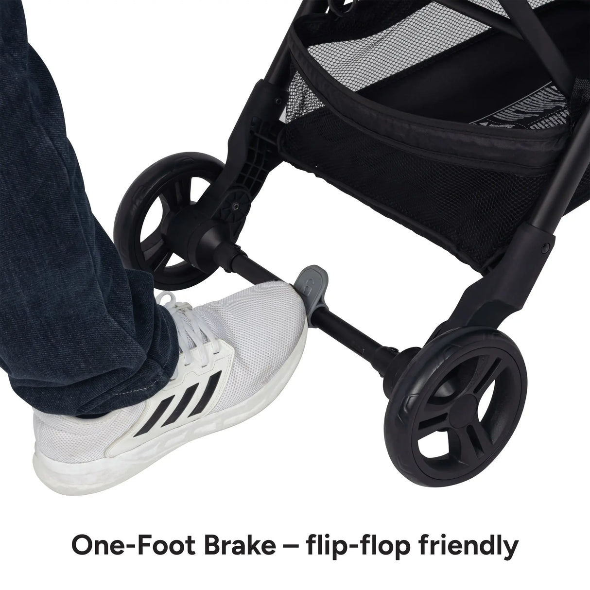 A foot is stepping on the one foot brake from the Baby Trend York Compact Stroller