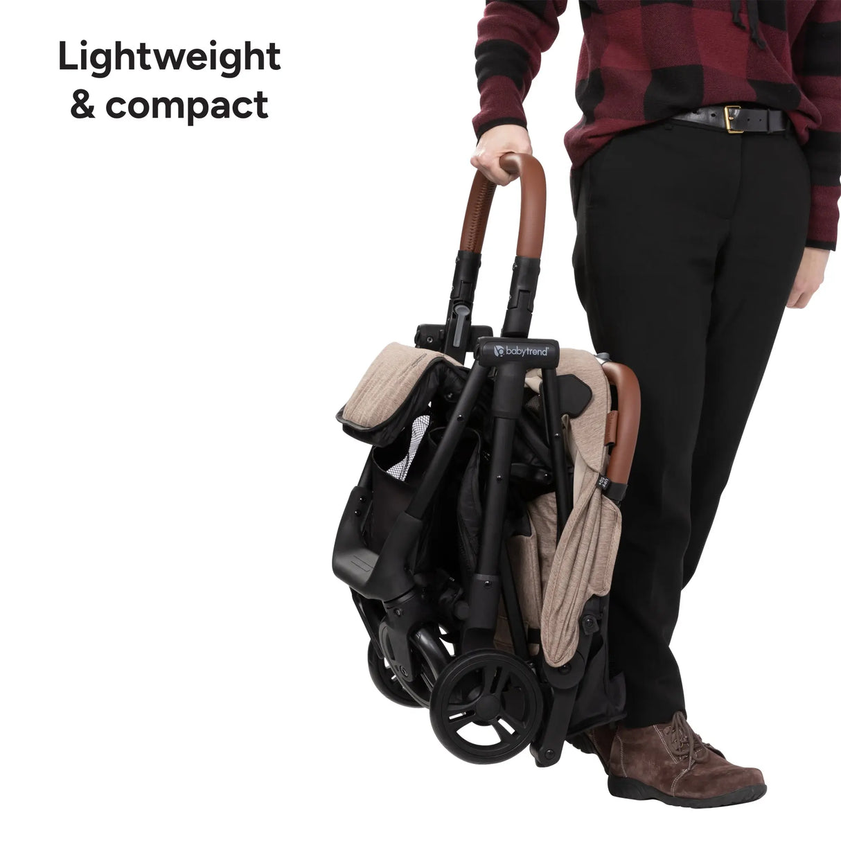 A person is holding up the Baby Trend York Compact Stroller as it is lightweight and compact