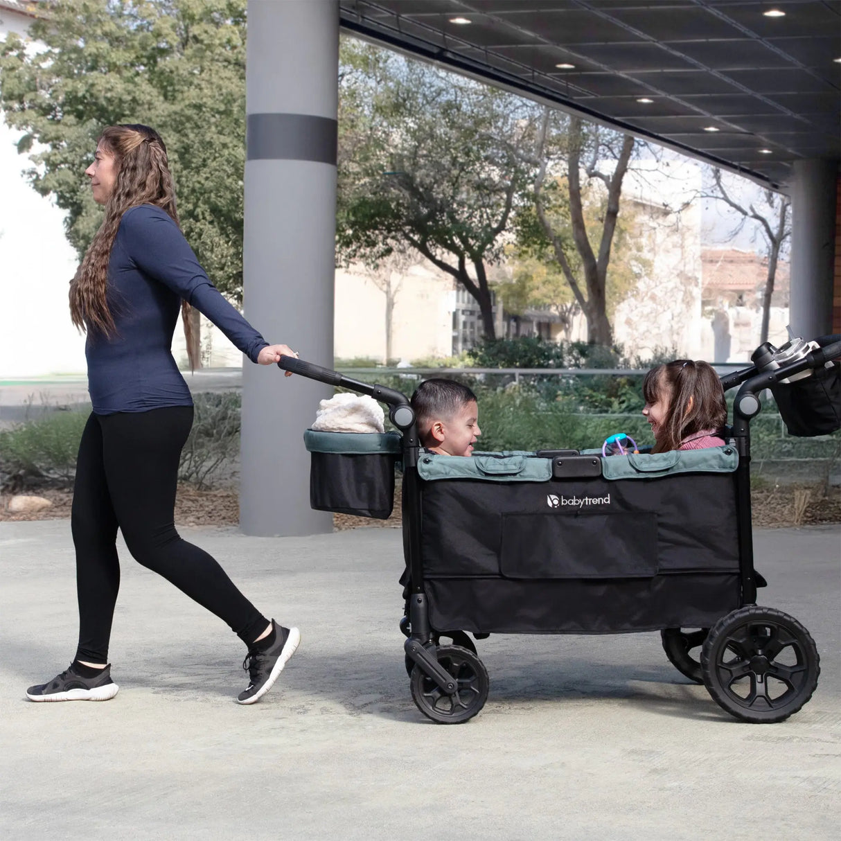 A mom is pulling her two children sitting in the Quest PLUS 3-in-1 Stroller Wagon