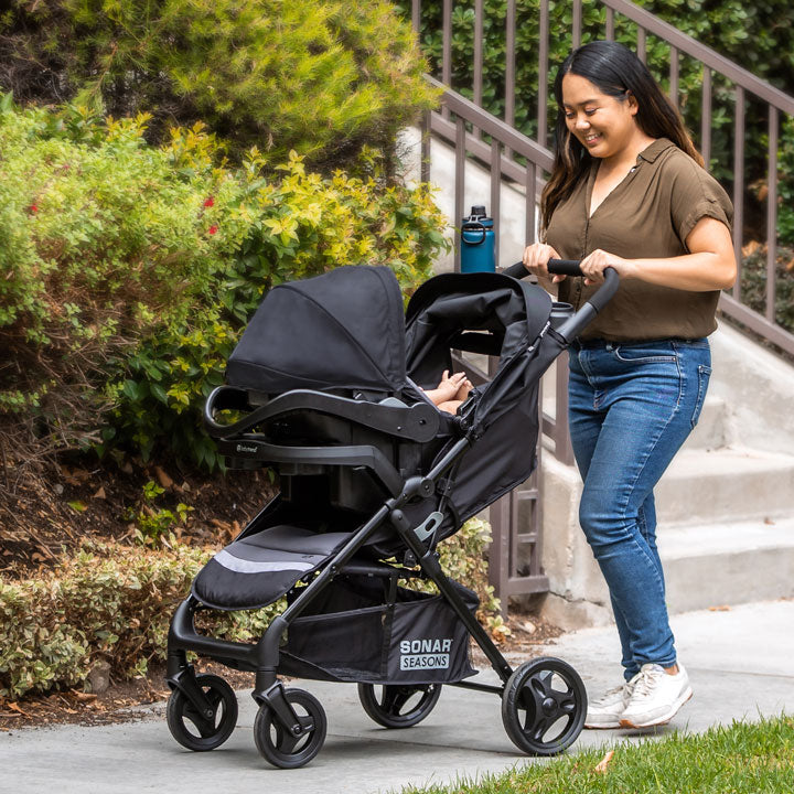 Baby Trend Sonar Seasons Travel System with EZ-Lift 35 Infant Car Seat with mother pushing infant child