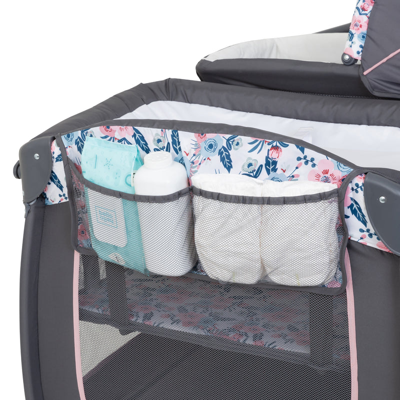 Pocket storage for diapers and accessories included with the Baby Trend Lil' Snooze Deluxe II Nursery Center Playard