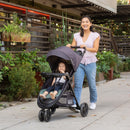 Load image into gallery viewer, Mom is pushing her child in the Baby Trend Sonar Cargo 3-Wheel Stroller Travel System