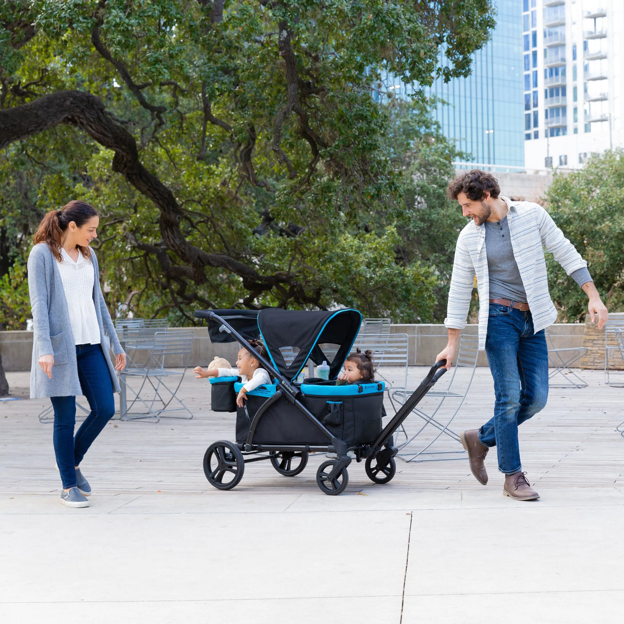 Parents taking their two child on a stroll with the Baby Trend Expedition 2-in-1 Stroller Wagon PLUS