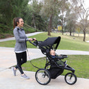 Load image into gallery viewer, Parent strolling with her child in the Baby Trend Quick Step Jogging Stroller