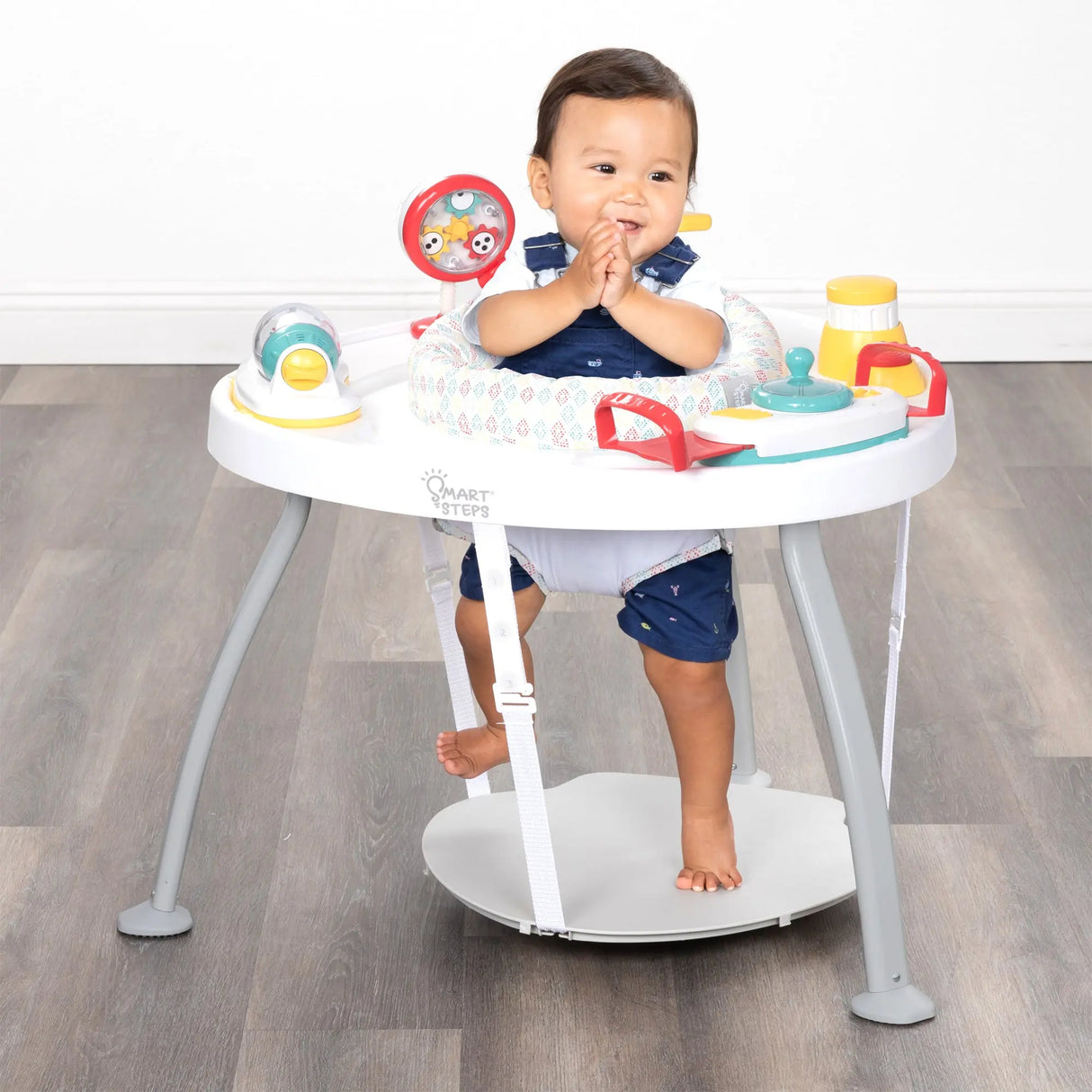 A child sitting in the Smart Steps Hop N' Discover 3-in-1 Activity Center