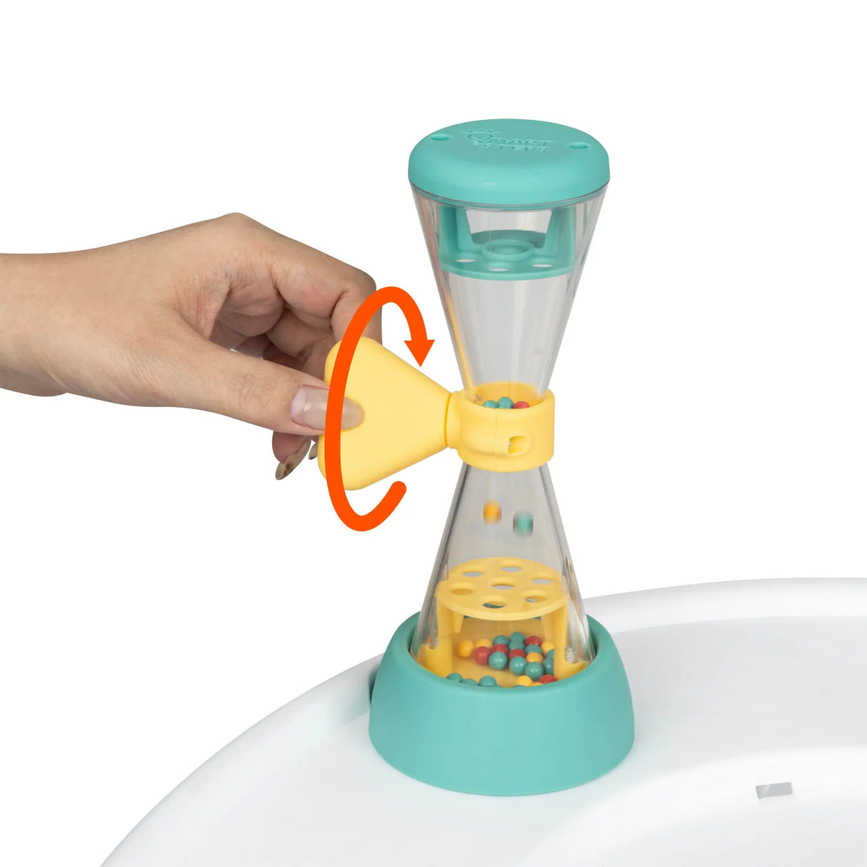 Colorful toy with a cone-shaped top and cylindrical body, held by a hand from the Smart Steps Hop N' Discover 3-in-1 Activity Center