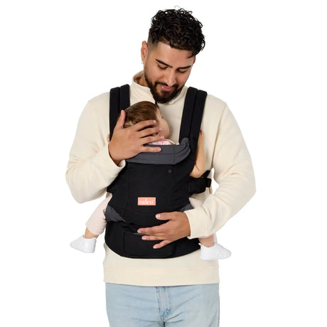 A man carrying a child in the Caleo 3-in-1 Newborn Carrier