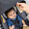 A mom is blocking sun from her child with the canopy on the Baby Trend EZ-Lift PLUS Infant Car Seat