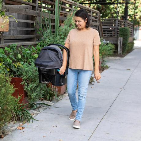 Mom is carrying the Baby Trend EZ-Lift PRO Infant Car Seat with the ez-side grip