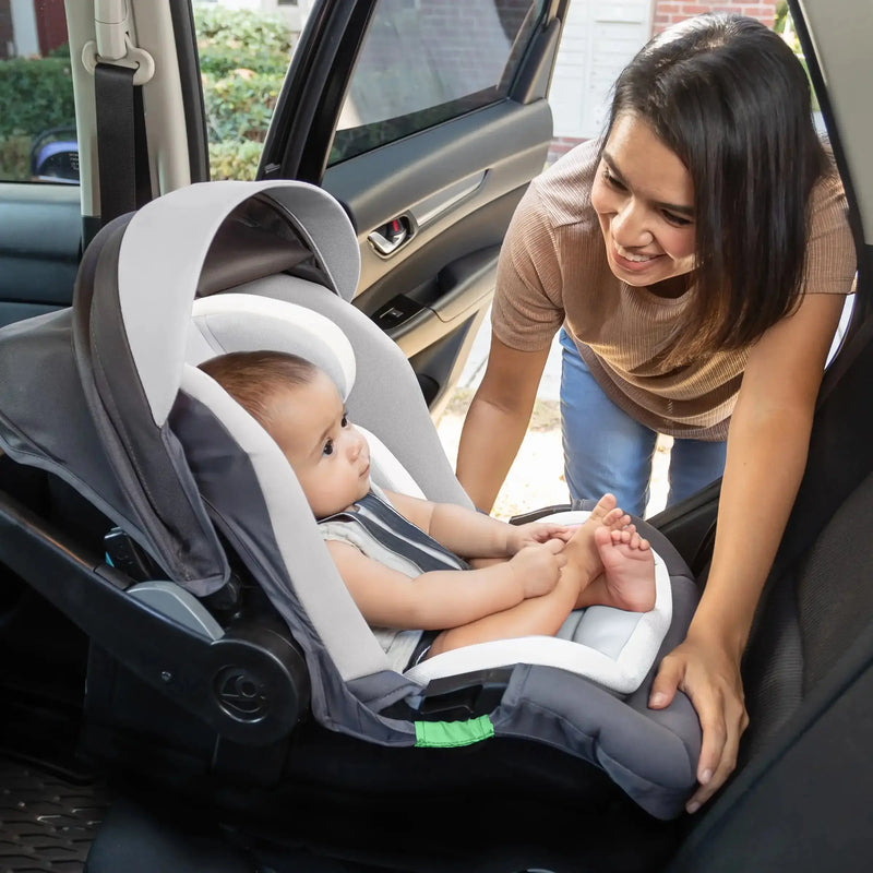 A mom is looking after her child sitting in the Baby Trend Secure-Lift LTE Infant Car Seat