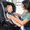 A mom is placing her child in the Baby Trend Trooper SLIM 3-in-1 Convertible Car Seat