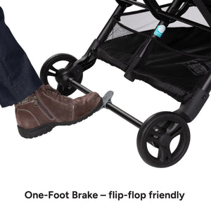 One-foot brake mechanism on a Baby Trend York Compact Side-By-Side Double Stroller with a foot pressing down on it