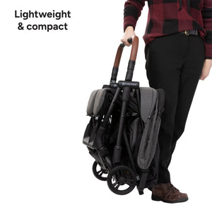Person holding a compact and lightweight Baby Trend York Compact Side-By-Side Double Stroller