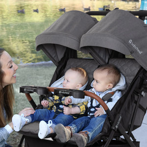 Woman with two children in a Baby Trend York Compact Side-By-Side Double Stroller by a lake