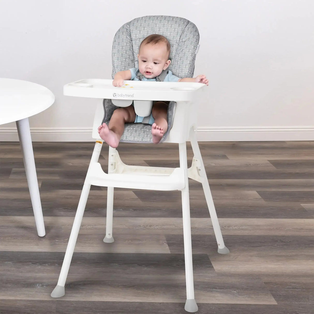 A child is sitting in the Baby Trend Adapt 4-in-1 High Chair