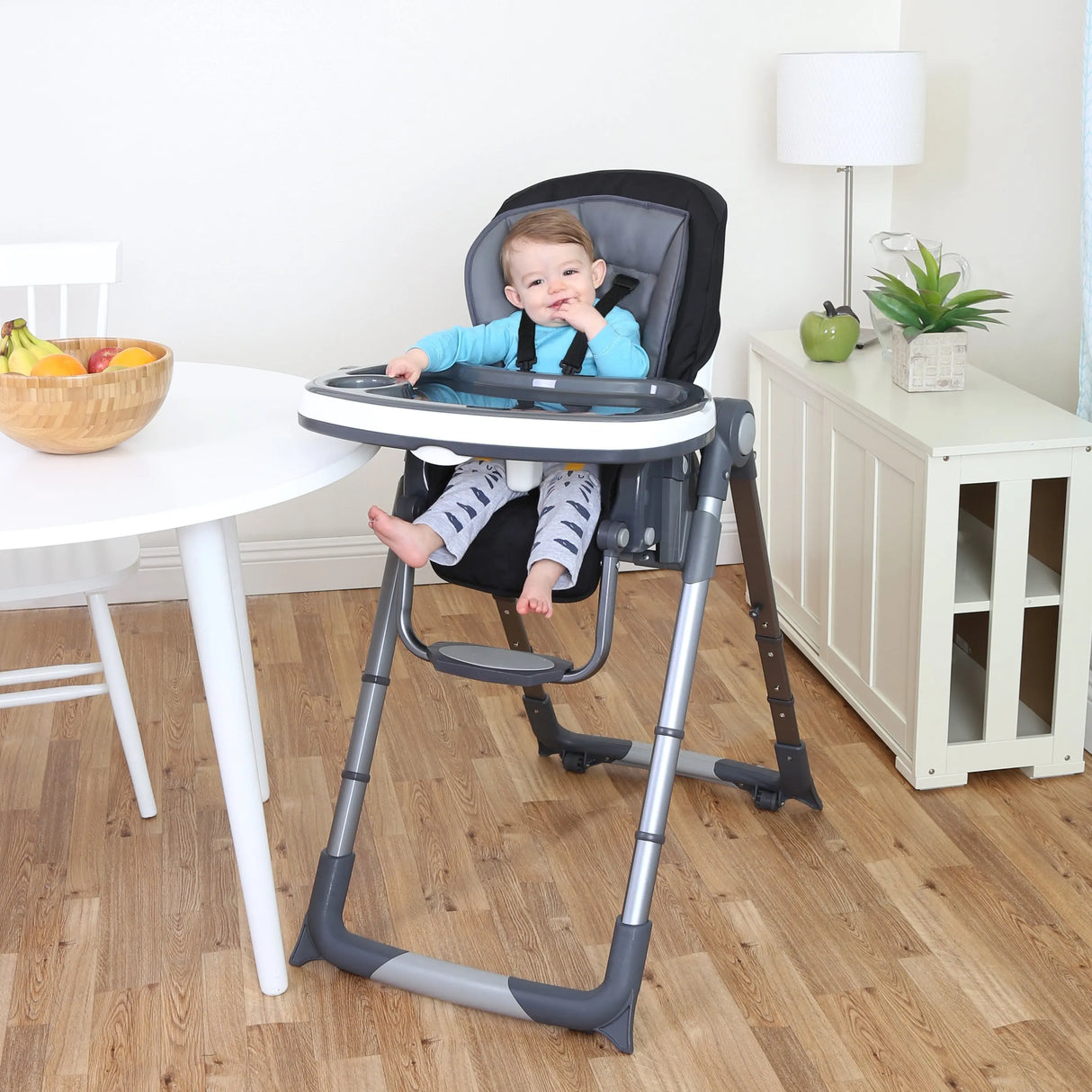 A child is sitting in the 7-In-1 Feeding Center High Chair of a dining room