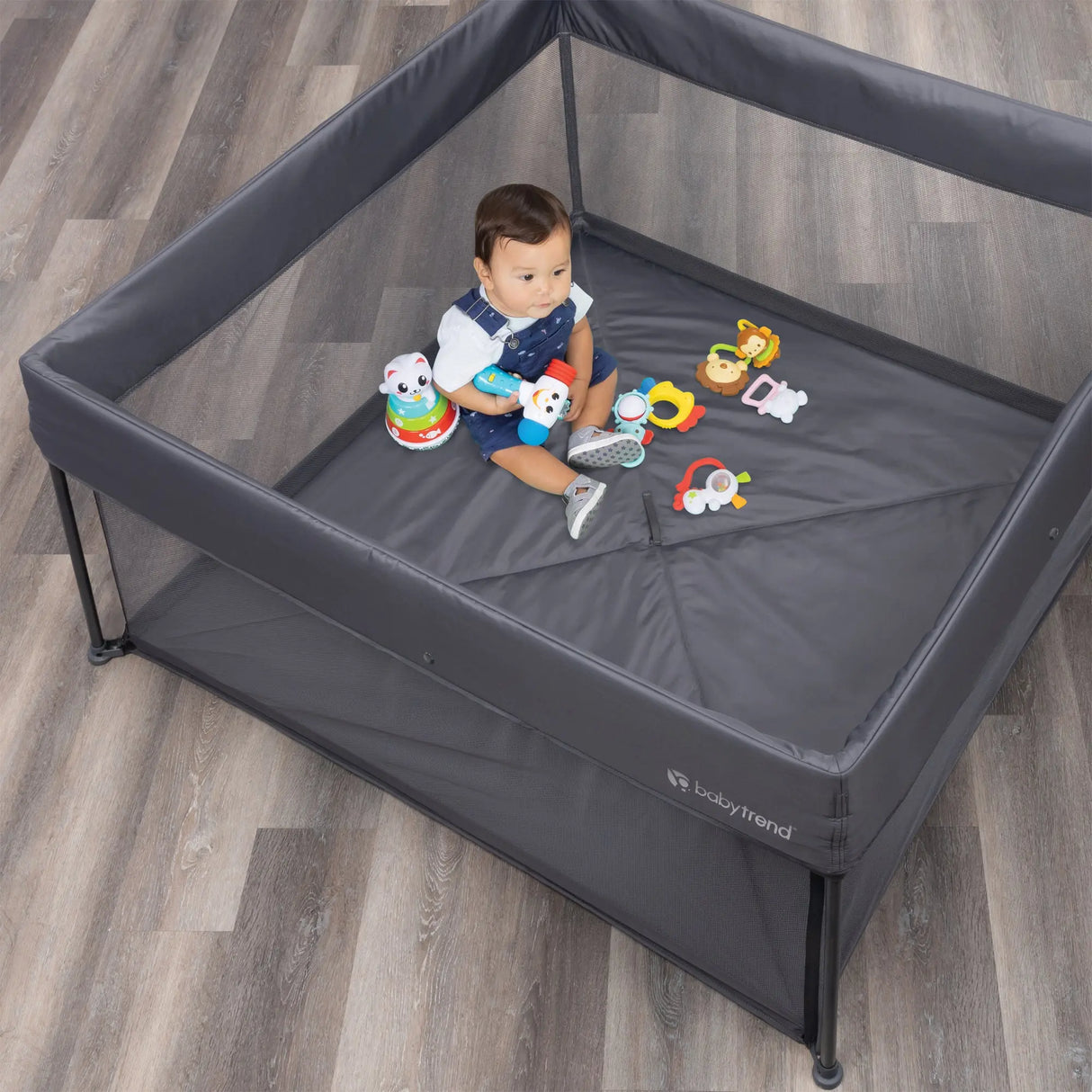 A child is sitting in the Play Zone Play Space with Compact Fold