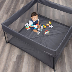 A child is sitting in the Play Zone Play Space with Compact Fold