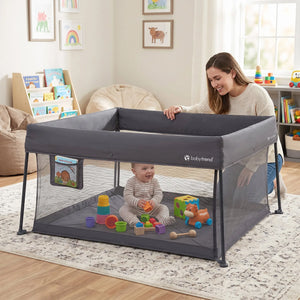 A mom is watching her child inside the Baby Trend Play Zone Play Space within their home