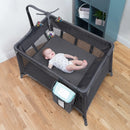 Load image into gallery viewer, A child laying in the Baby Trend Sol Nursery Center Playard