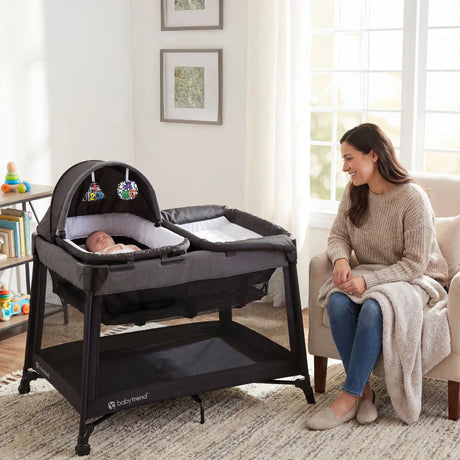 A mom is watching her child sleeping the napper of the Baby Trend Willow Nursery Center Playard