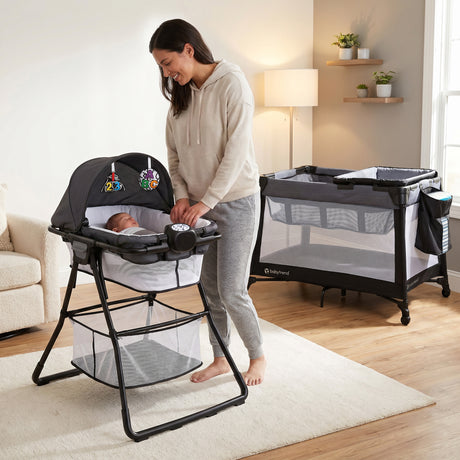 A mom is watching her child nap in the napper of the Baby Trend Willow Nursery Center Playard inside their home