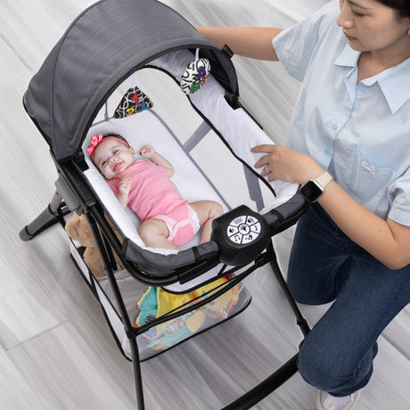 A mom is watching her child laying in the Baby Trend Willow Nursery Center Playard napper
