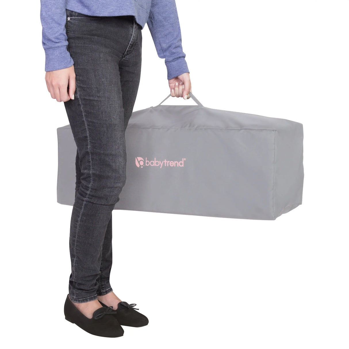 A mother is holding the folded Baby Trend EZ Rest Playard