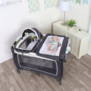 Load image into gallery viewer, A child laying in the Baby Trend Lil' Snooze Deluxe II Nursery Center Playard