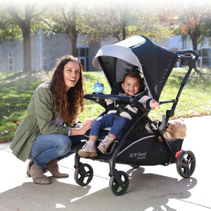 A mother with her child in the Baby Trend Sit N Stand 5-in-1 Shopper Stroller at a park