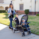 Load image into gallery viewer, Mom is out door with her children in the Baby Trend Sit N' Stand Ultra Stroller