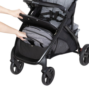 A person is accessing the front storage basket of the Baby Trend Tango Stroller
