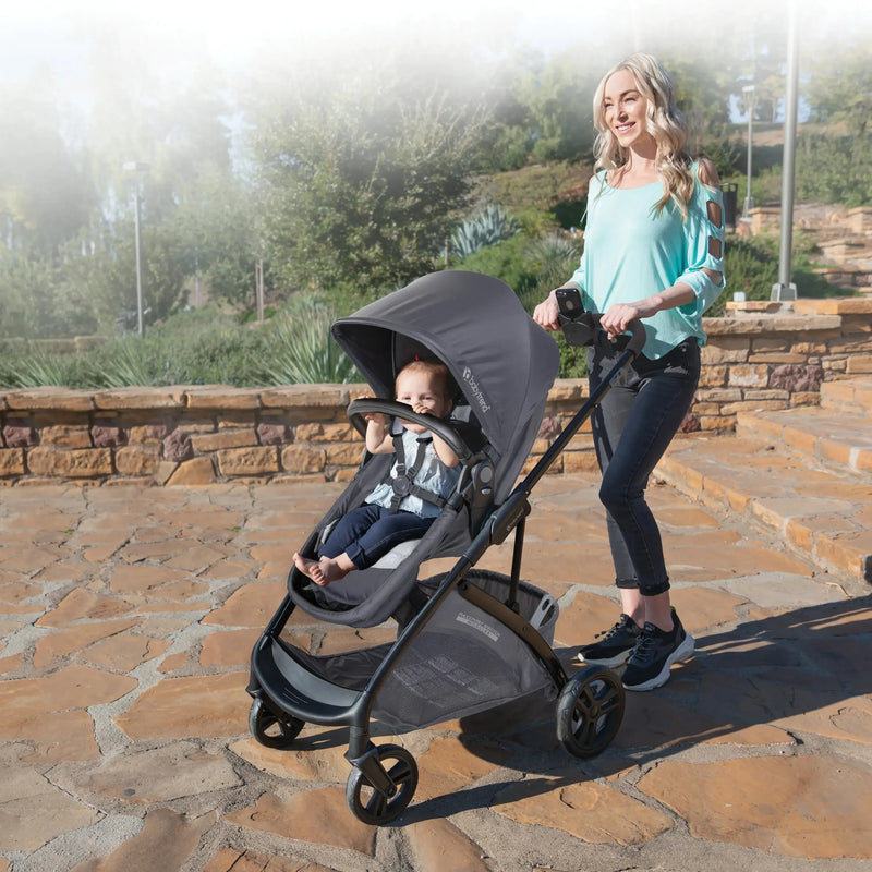 A mom strolling her child in the Baby Trend Passport Switch Modular Stroller