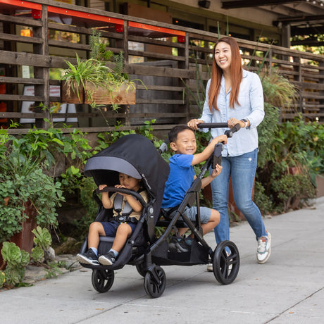 A mom is pushing her two children using the Baby Trend Morph Single to Double Modular Stroller