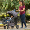 Mom and her child taking a stroll in the park with the Baby Trend Passport Carriage Stroller