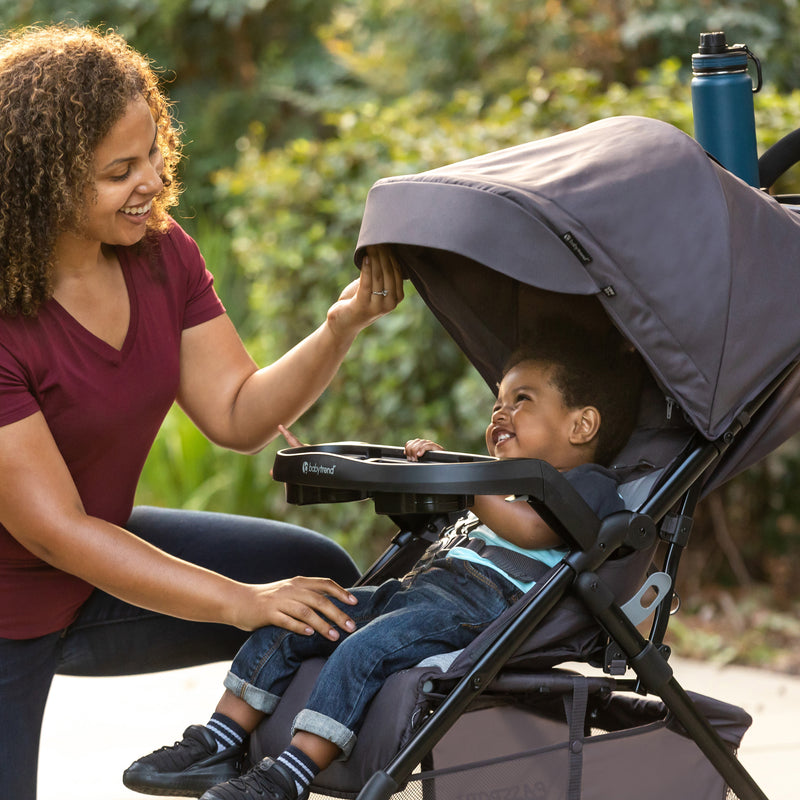 A mother and her child outdoor with the Baby Trend Passport Carriage Stroller
